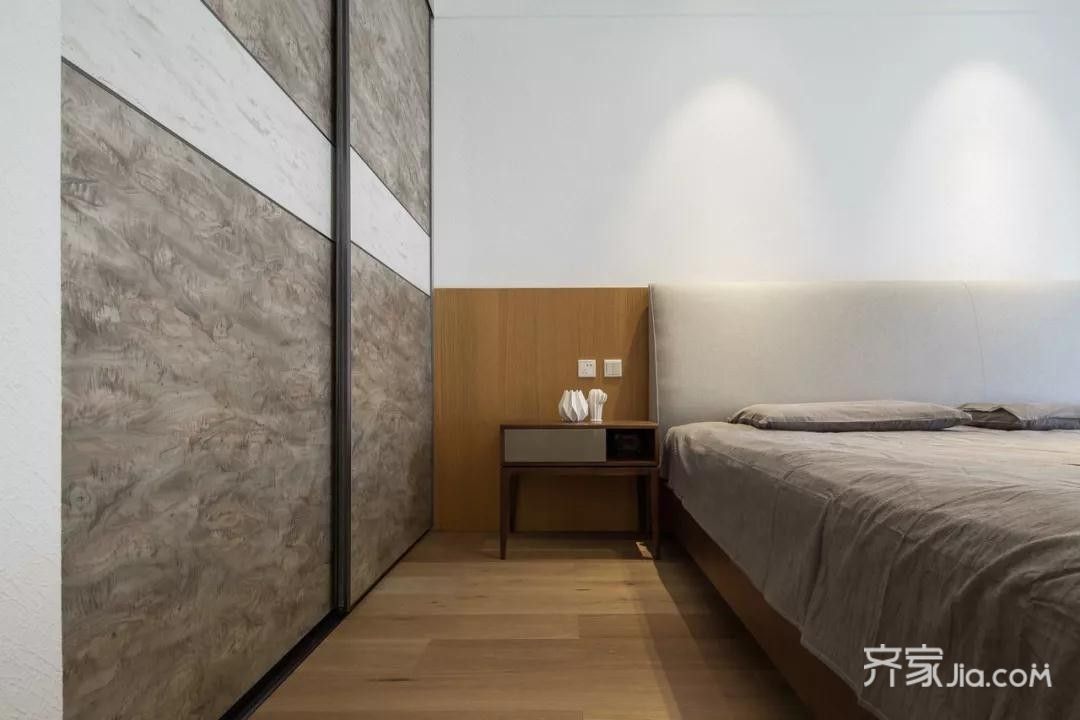卧室的木地板与木质床头背景墙,暖灰色的床单搭配,整体轻松自然的空间