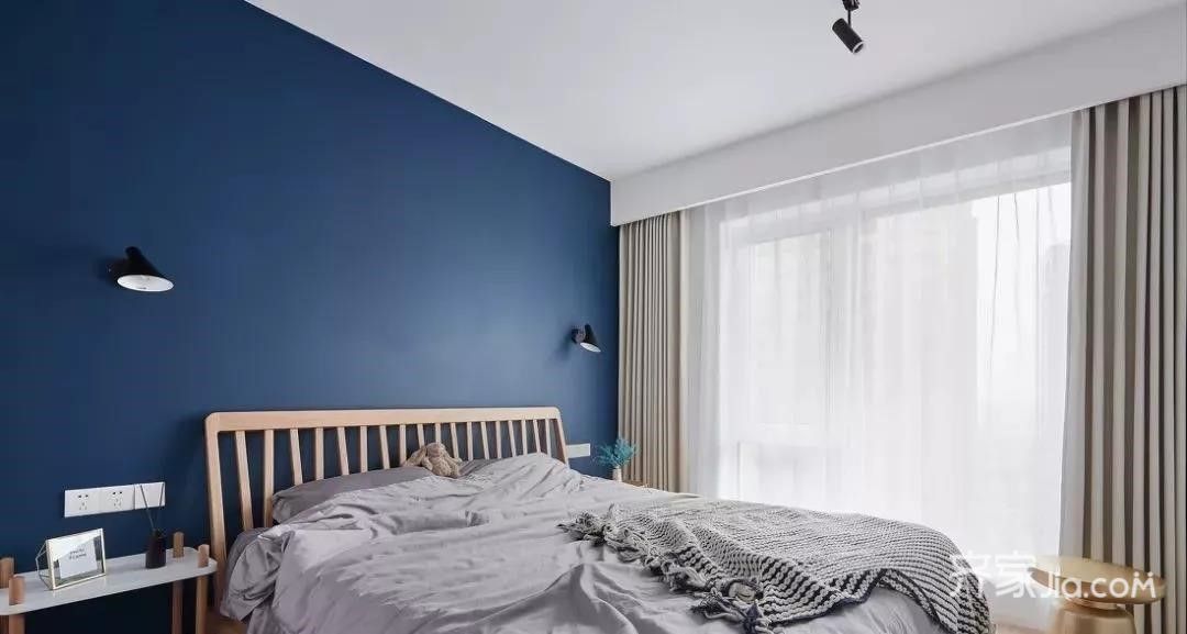 主卧非常大胆的选择了深蓝色墙面搭配原木大床以及灰色床品营造安静