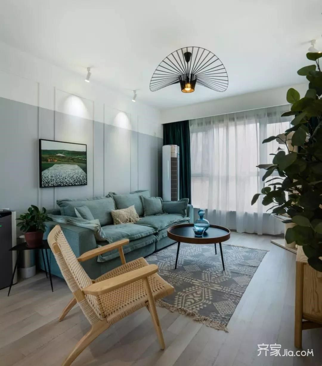 宽敞的客厅,整体以莫兰迪色系的雾霾蓝搭配木质家具和绿植,自然又