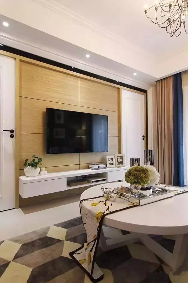 客厅以饱满的中性色配合白色和木色,沙发背后灰色的沙发墙简约淡雅