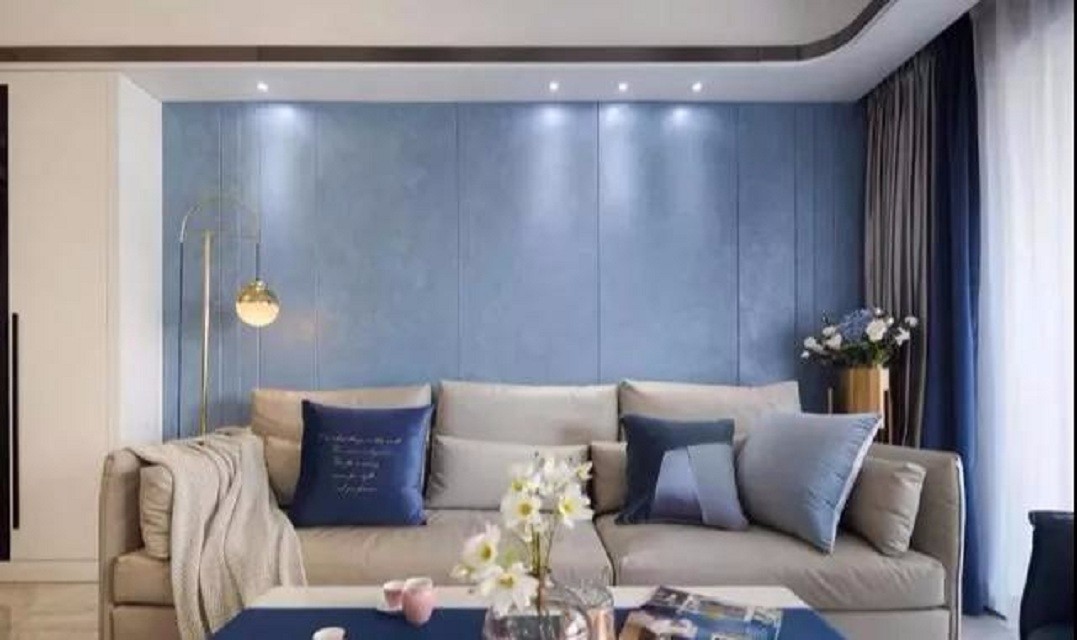 客厅的沙发背景墙采用了雅致的蓝色硬包,与电视背景墙的白色形成强烈
