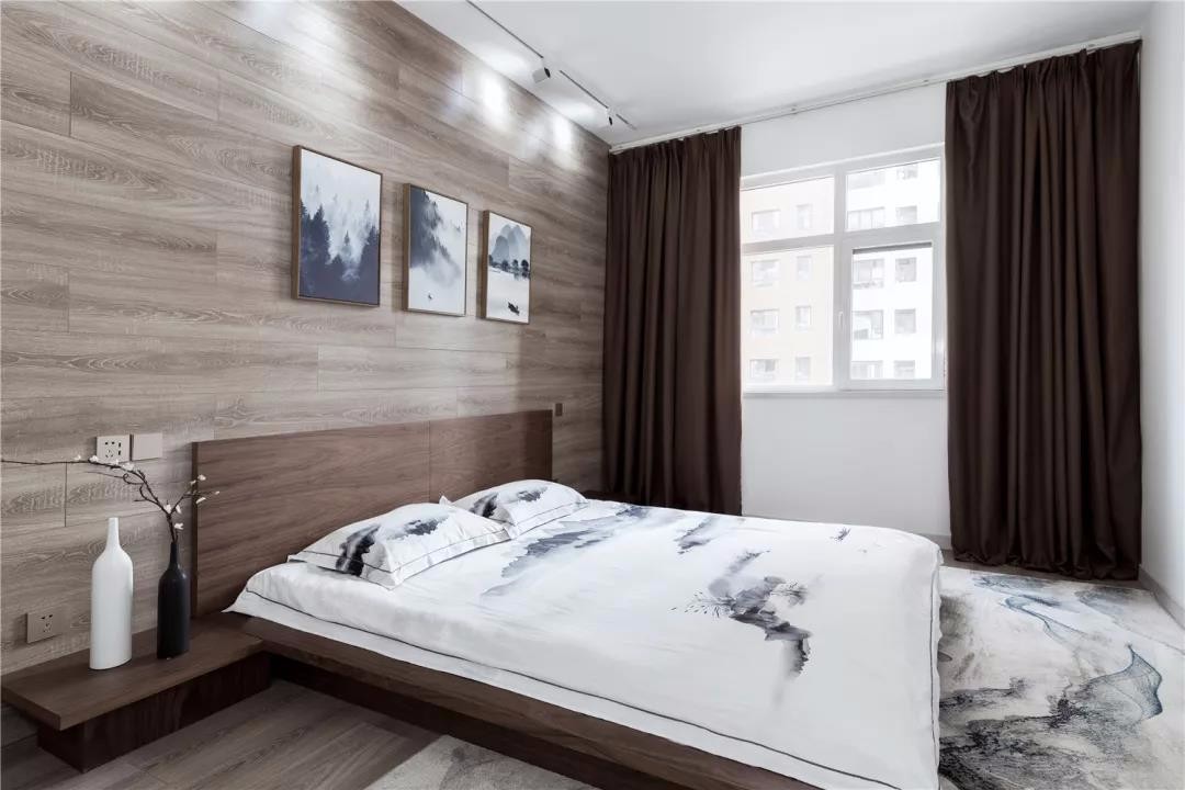 次卧以木纹砖上墙铺贴,床头墙挂上三幅的墨色装饰画与床单地毯,斟体